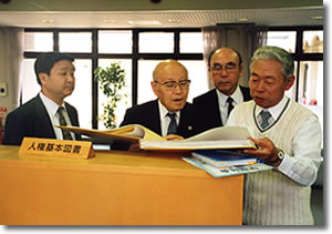 熱心に資料をのぞき込む中坊会長の写真